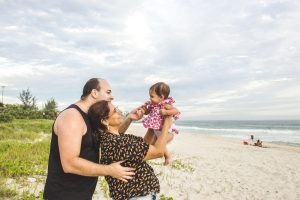 Mutter, Vater und Baby am Strand