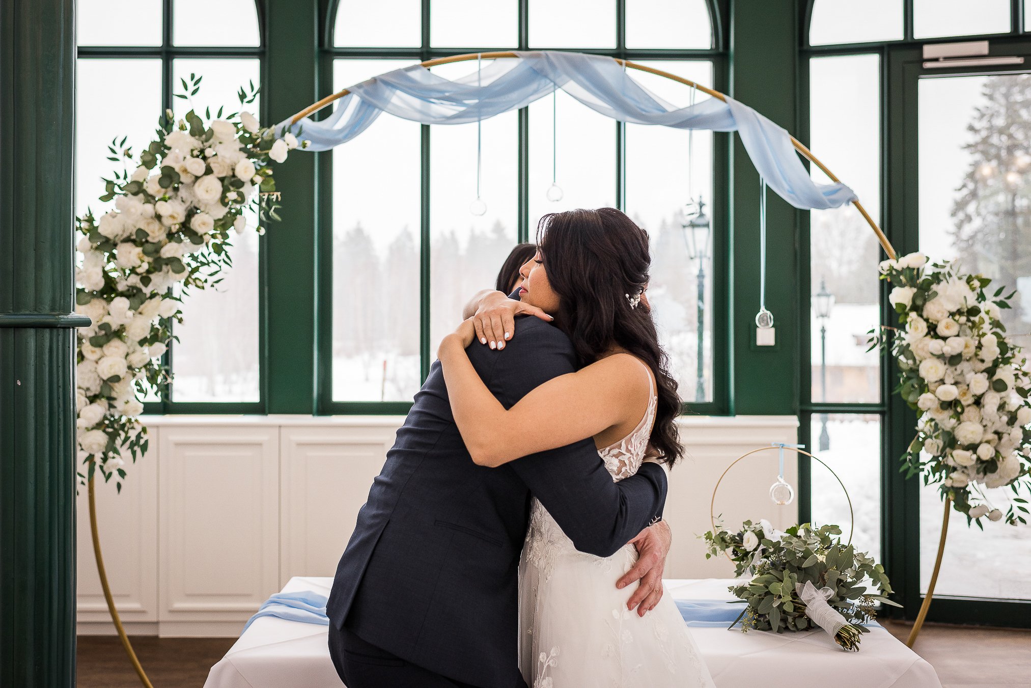 Winterhochzeit im Parkhotel Adler in Hinterzarten - Brautpaar umarmt sich nach der Trauung in der Pavillon Diva
