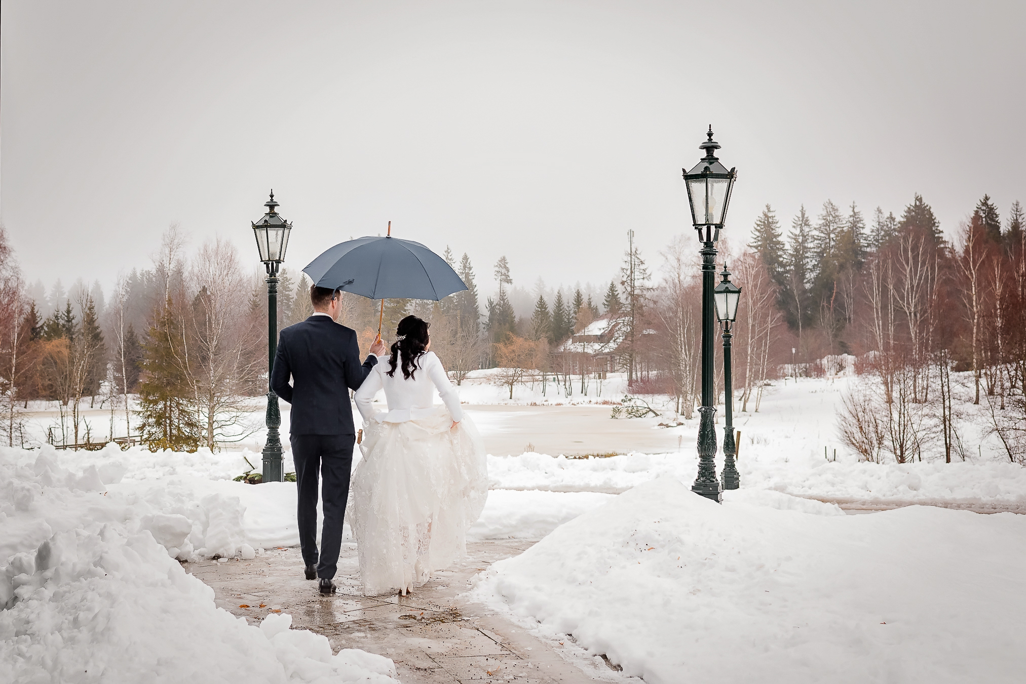 Ein Brautpaar läuft bei einer Winterhochzeit am Parkhotel Adler in Hinterzarten in der Schnee.