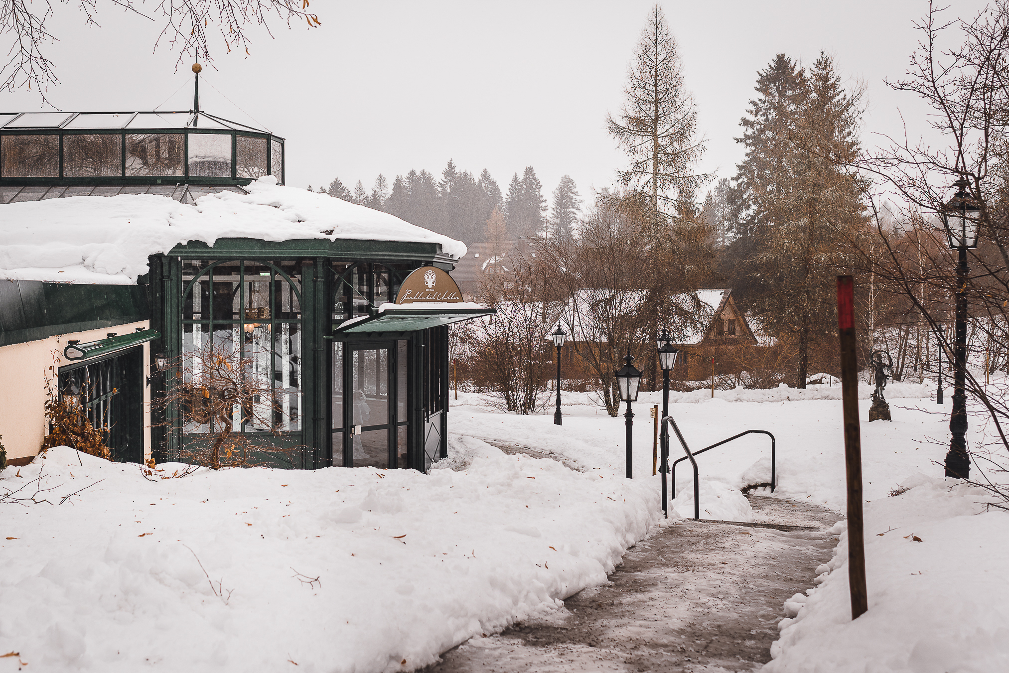 Winterhochzeit im Schwarzwald am Parkhotel Adler in Hinterzarten. Ein Foto des Pavillons Diva von außen mit verschneiter Landschaft und Tannenbäumen, die perfekte Kulisse für eine Winterhochzeit im Schwarzwald.