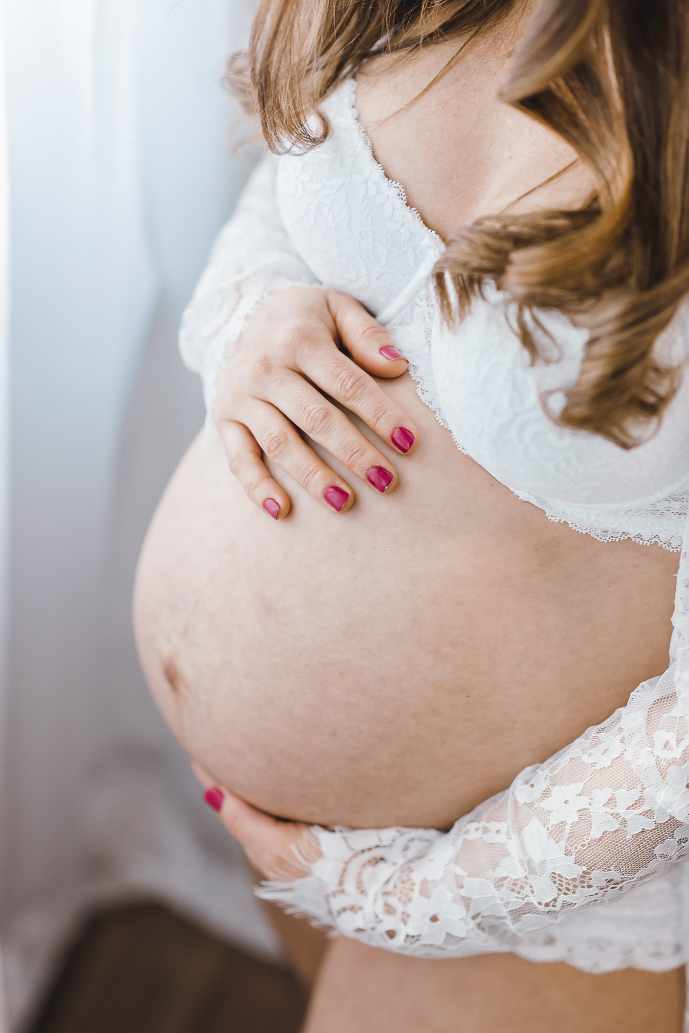 Schwangerschaft Fotoshooting in Freiburg, Close-up der Hände auf dem Babybauch