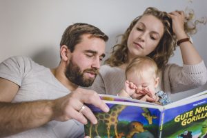 Lifestyle-Baby-Shooting in Freiburg - Familie liest gemeinsam im Bett