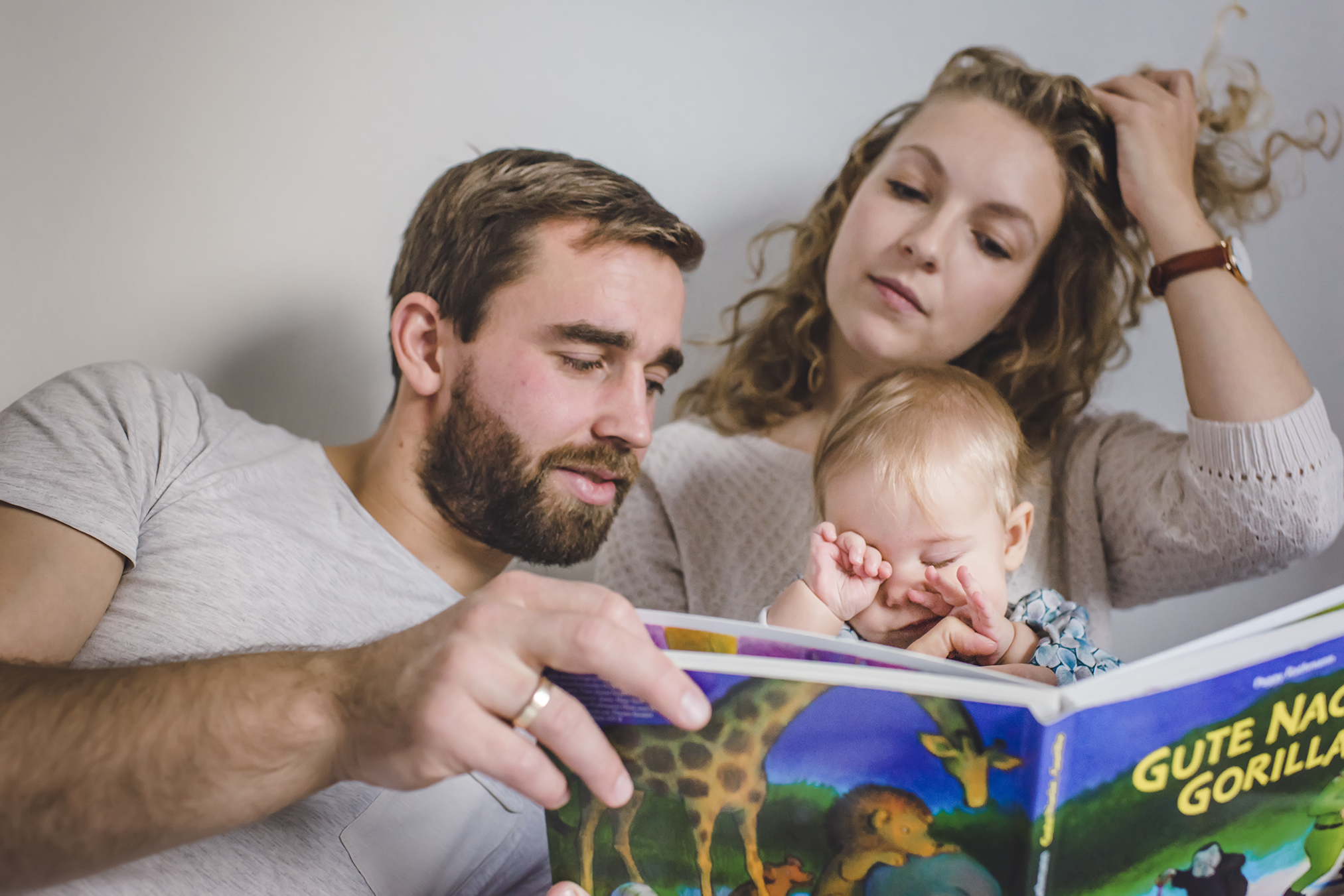 Lifestyle-Baby-Shooting in Freiburg - Familie liest gemeinsam im Bett