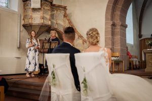 Ein Foto von Ulla Christ und Lisa-Marie Christ, die a capella Ave Maria bei einer Hochzeit in Offenburg singen, während das Brautpaar sie mit ganzer Hingabe beobachtet.