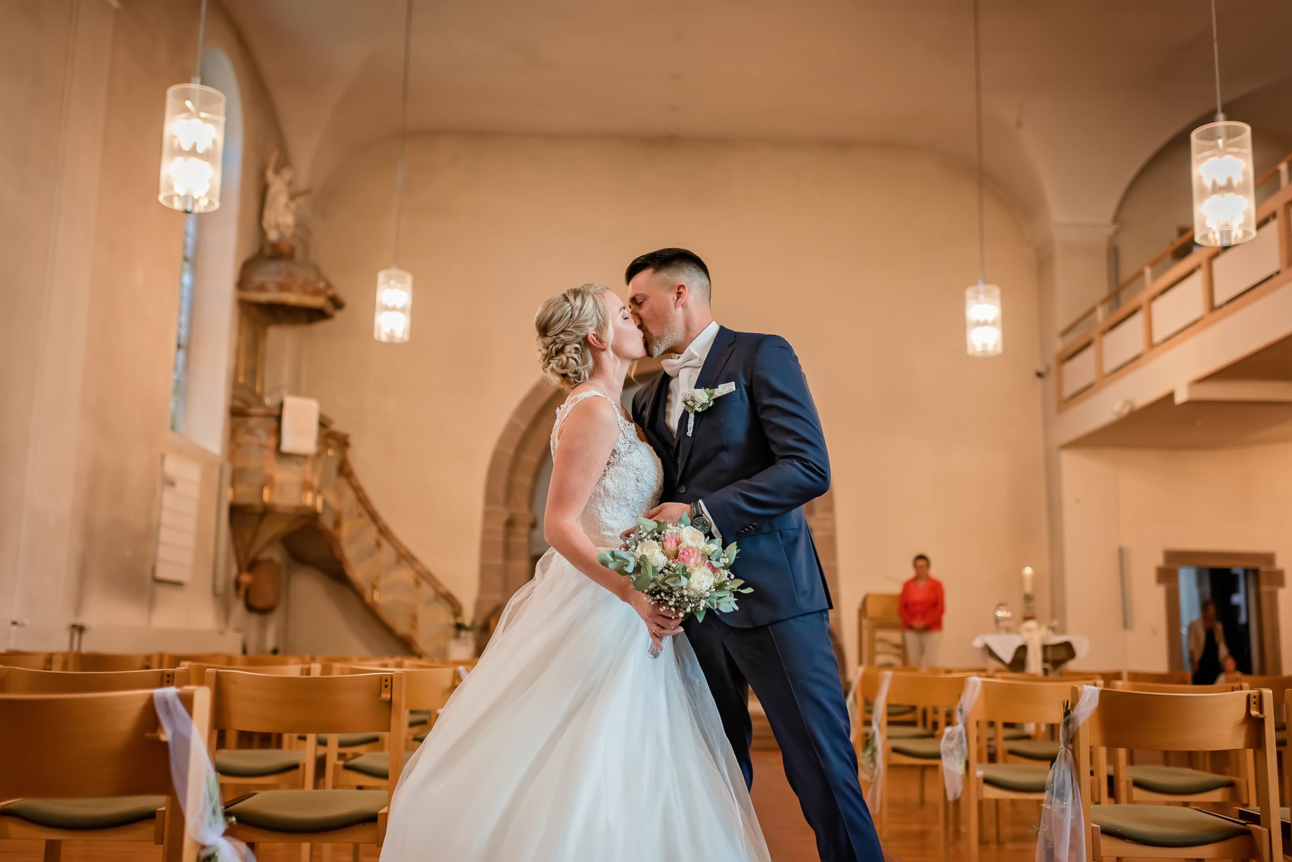 Brautpaar küsst sich romantisch nach der kirchlichen Trauung, fotografiert von Hochzeitsfotografin Isabela Campos in Offenburg.