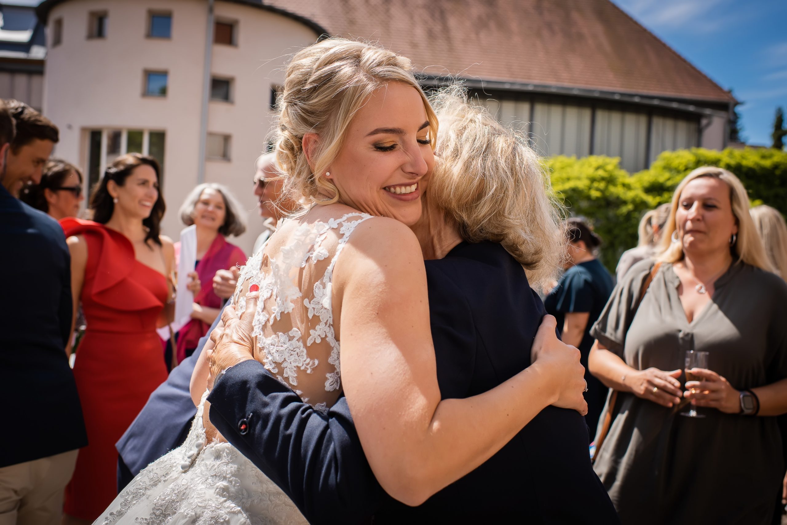 Eine Mutter umarmt ihre glückliche Tochter bei einem Hochzeits-Empfang in Friesenheim.