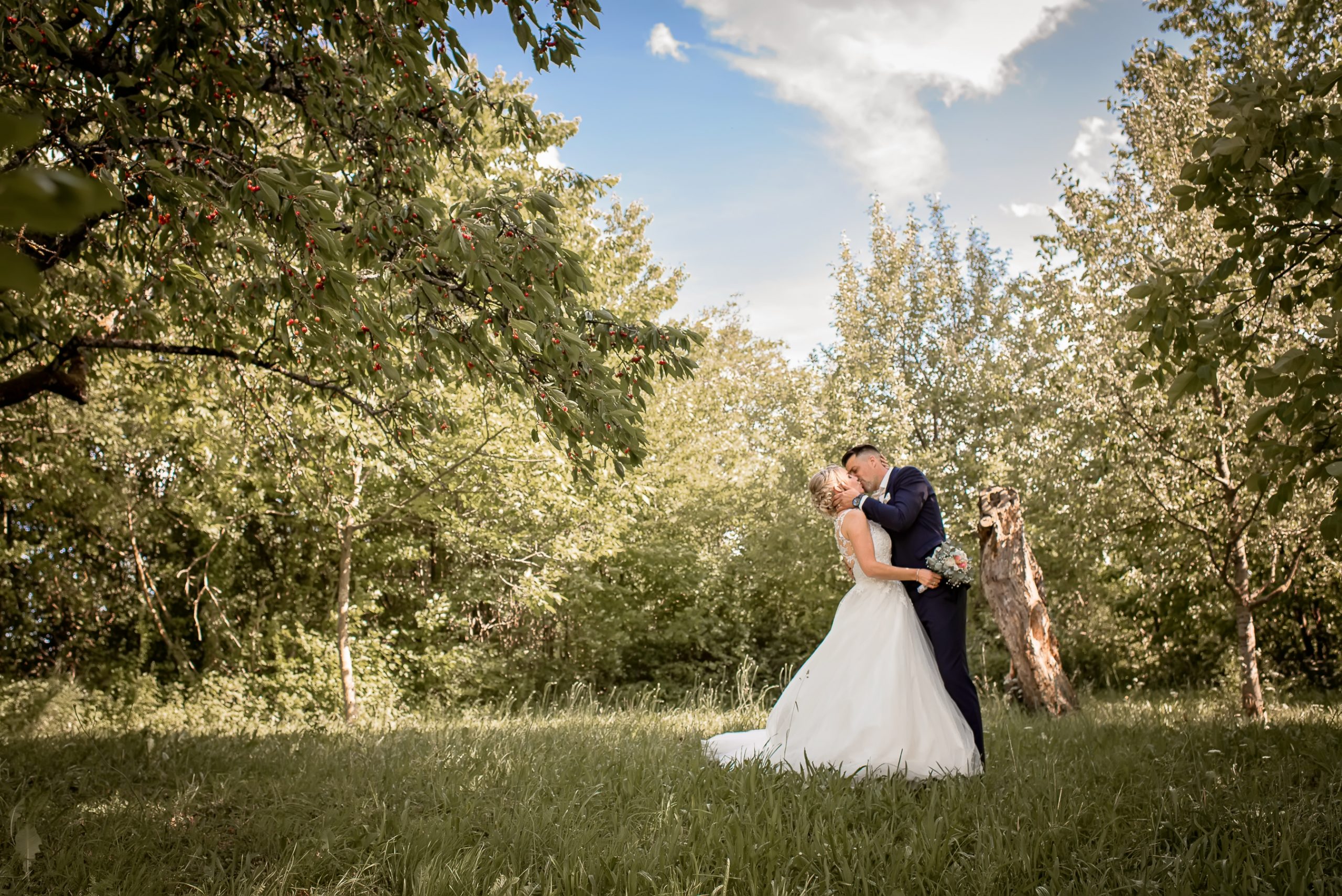 Ein glückliches Brautpaar küssen sich in der Natur nach ihrer Hochzeit in Friesenheim.