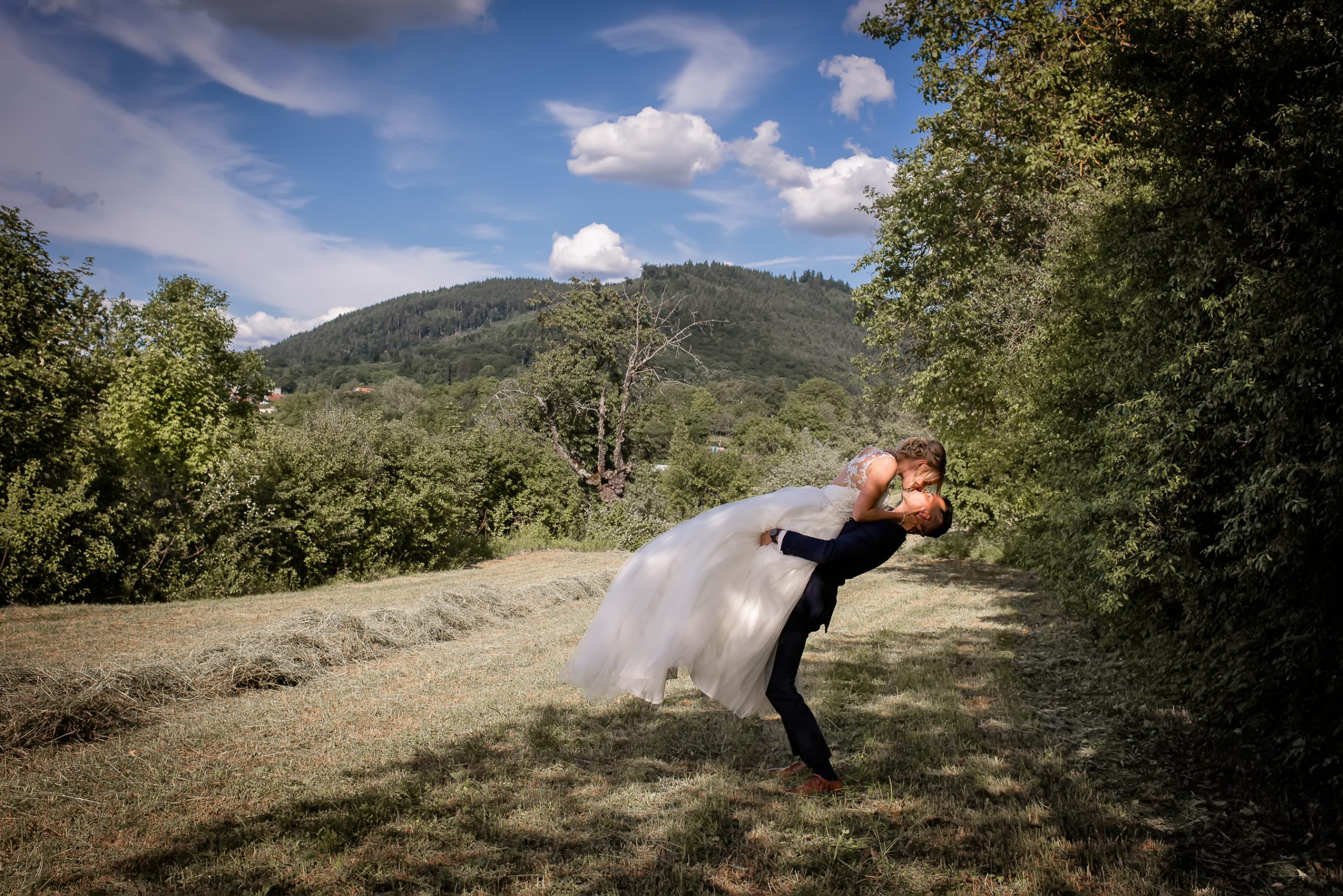 Ein Brautpaar posiert für ein romantisches Fotoshooting in der Natur.
