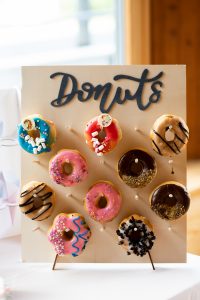 Eine Detailaufnahme einer Reihe bunter Donuts auf einem Candy-Bar-Tisch bei der Hochzeit
