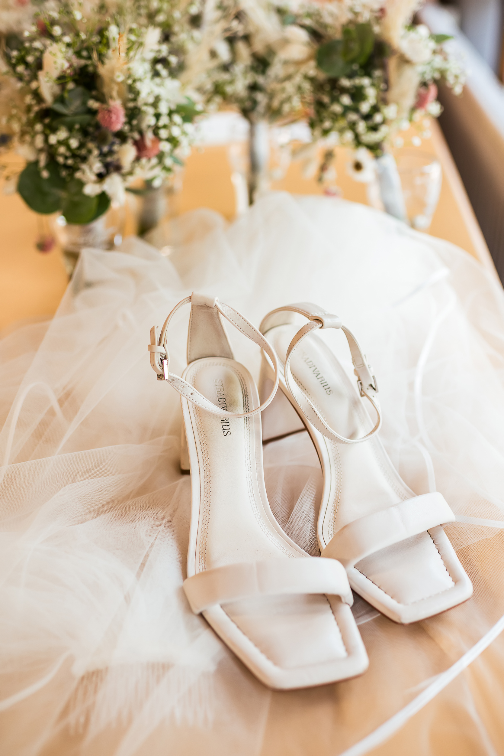 Detailaufnahme der Braut Sandalen und Hochzeitsschuhe mit weißem Schleier