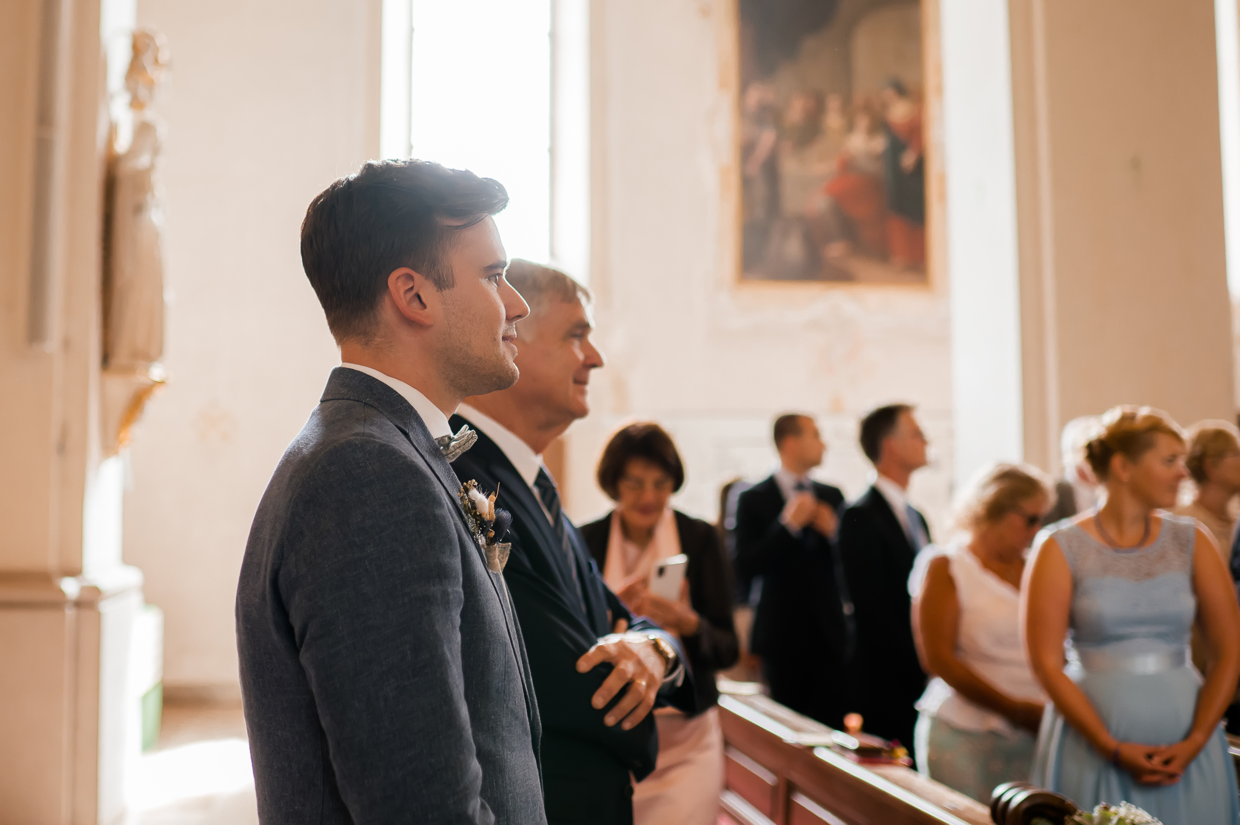 Eine seitliche Aufnahme des Bräutigams in der Wallfahrtskirche Todtmoos. Er steht neben seinem Vater und schaut in Richtung Kirchentür, wo die Braut kommt.