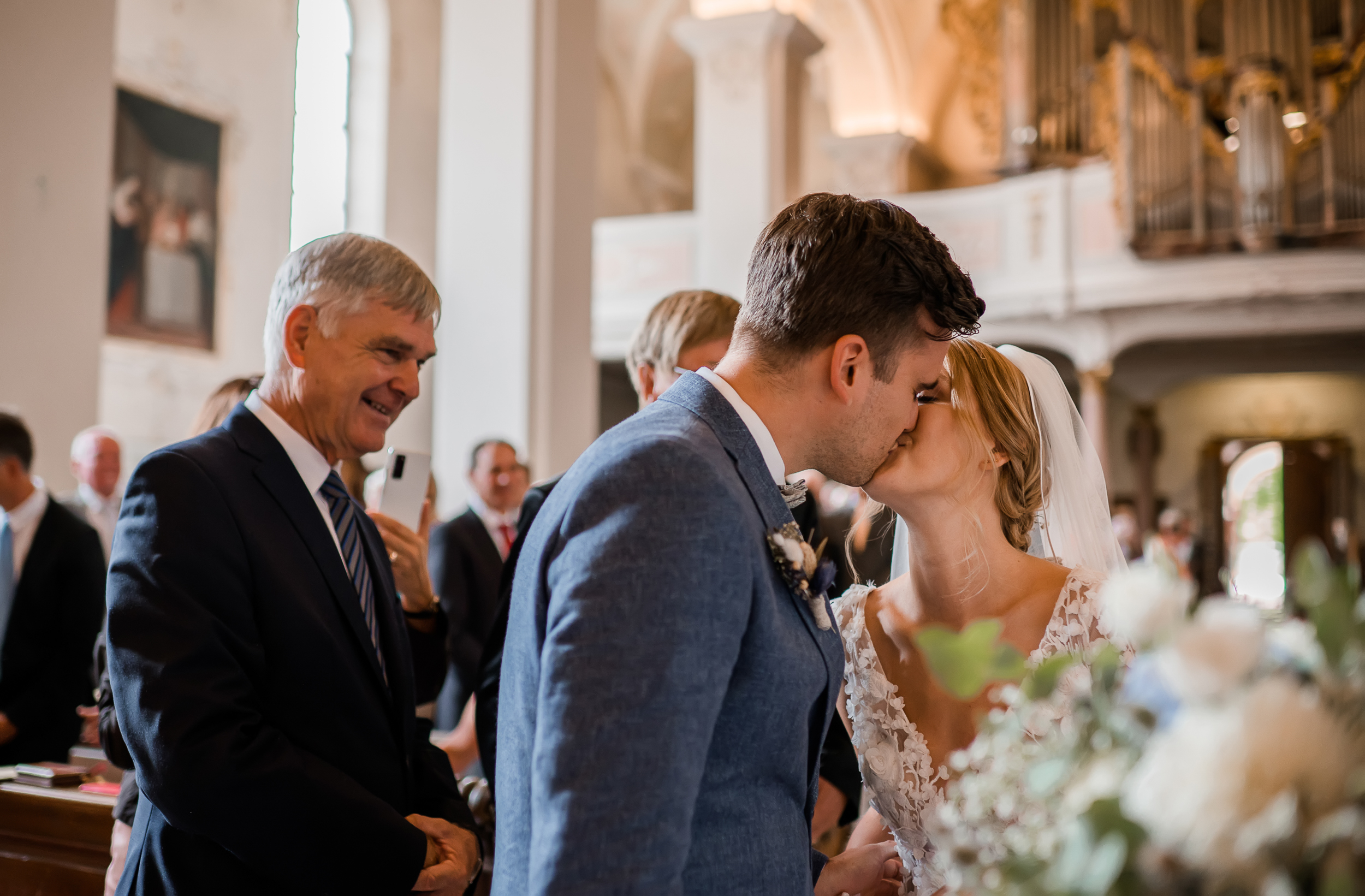Kirchliche Trauung in der Wallfahrtskirche Todtmoos, der Bräutigam küsst die Braut im Altar bei der Zeremonie. Fotografiert von der Hochzeitsfotografin Isabela Campos.