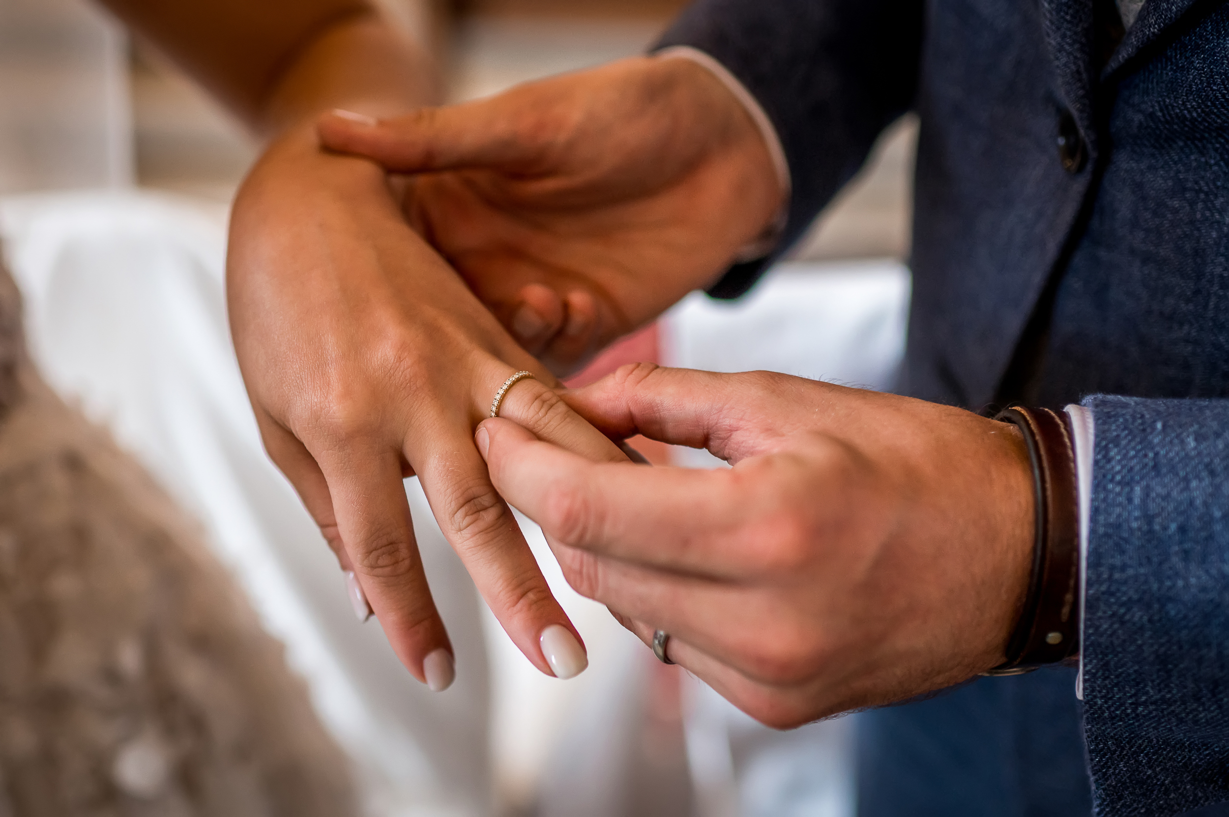 Der Bräutigam steckt den Hochzeitsring an den Finger der Braut.