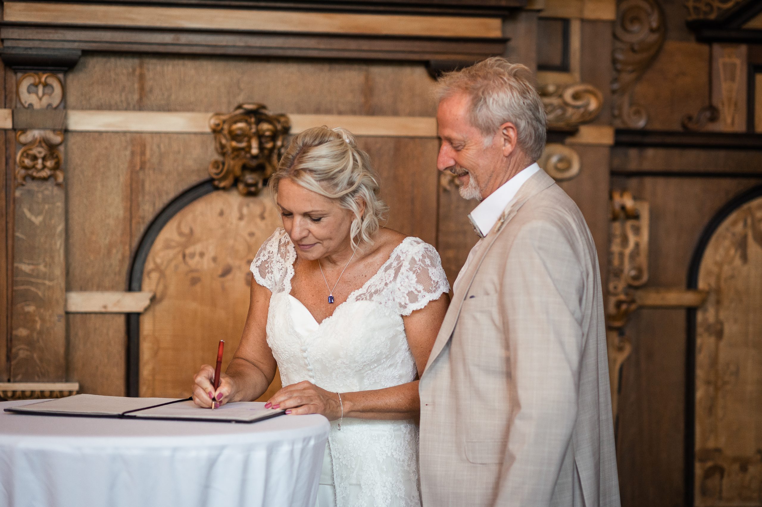 Ein Brautpaar unterschreibt das Hochzeitsbuch während der standesamtlichen Trauung im Freiburger Rathaus.