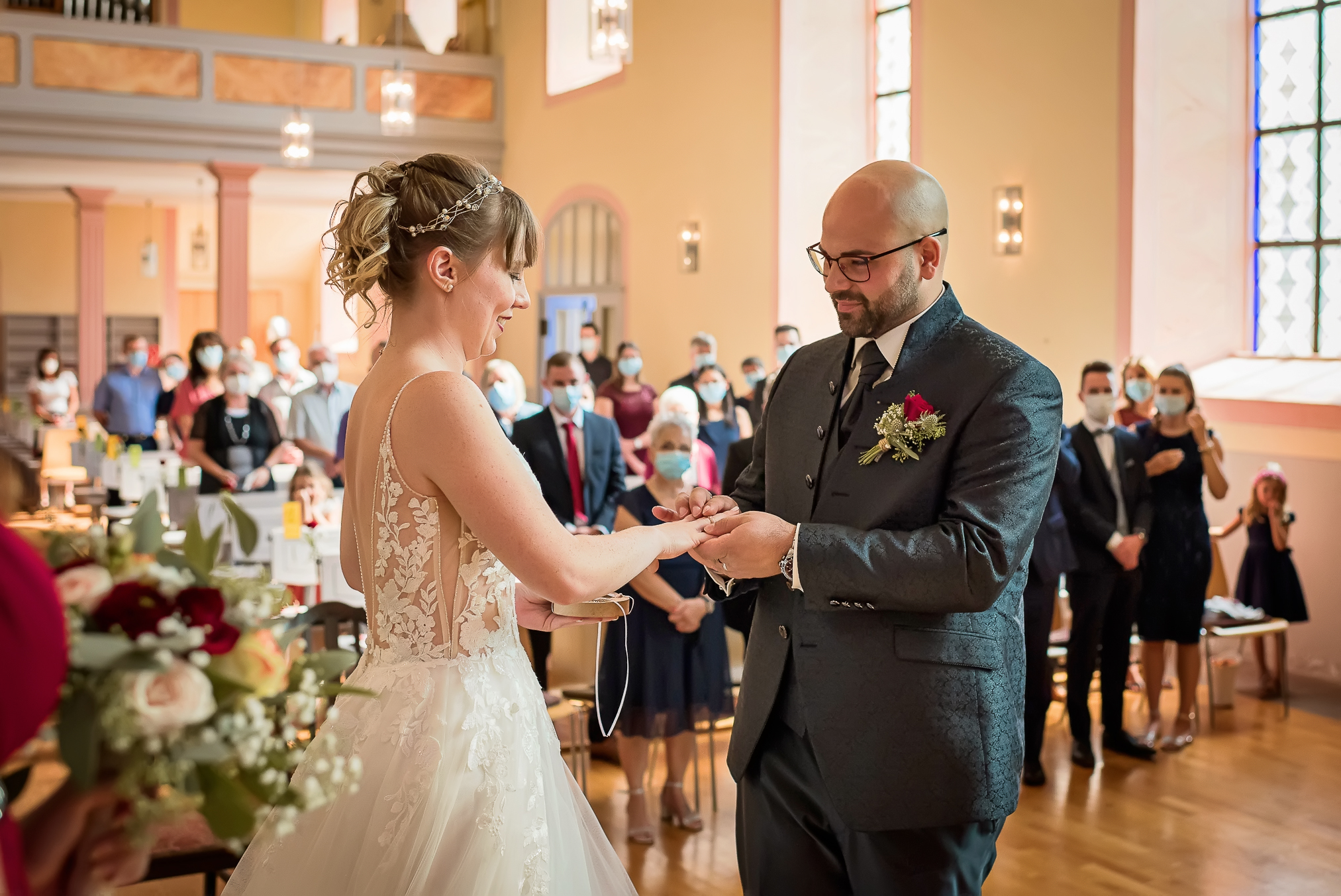 Foto des Moments, in dem der Bräutigam während der kirchlichen Trauung in der Ev. Martinskirche in Lahr den Ring an den Finger der Braut steckt.