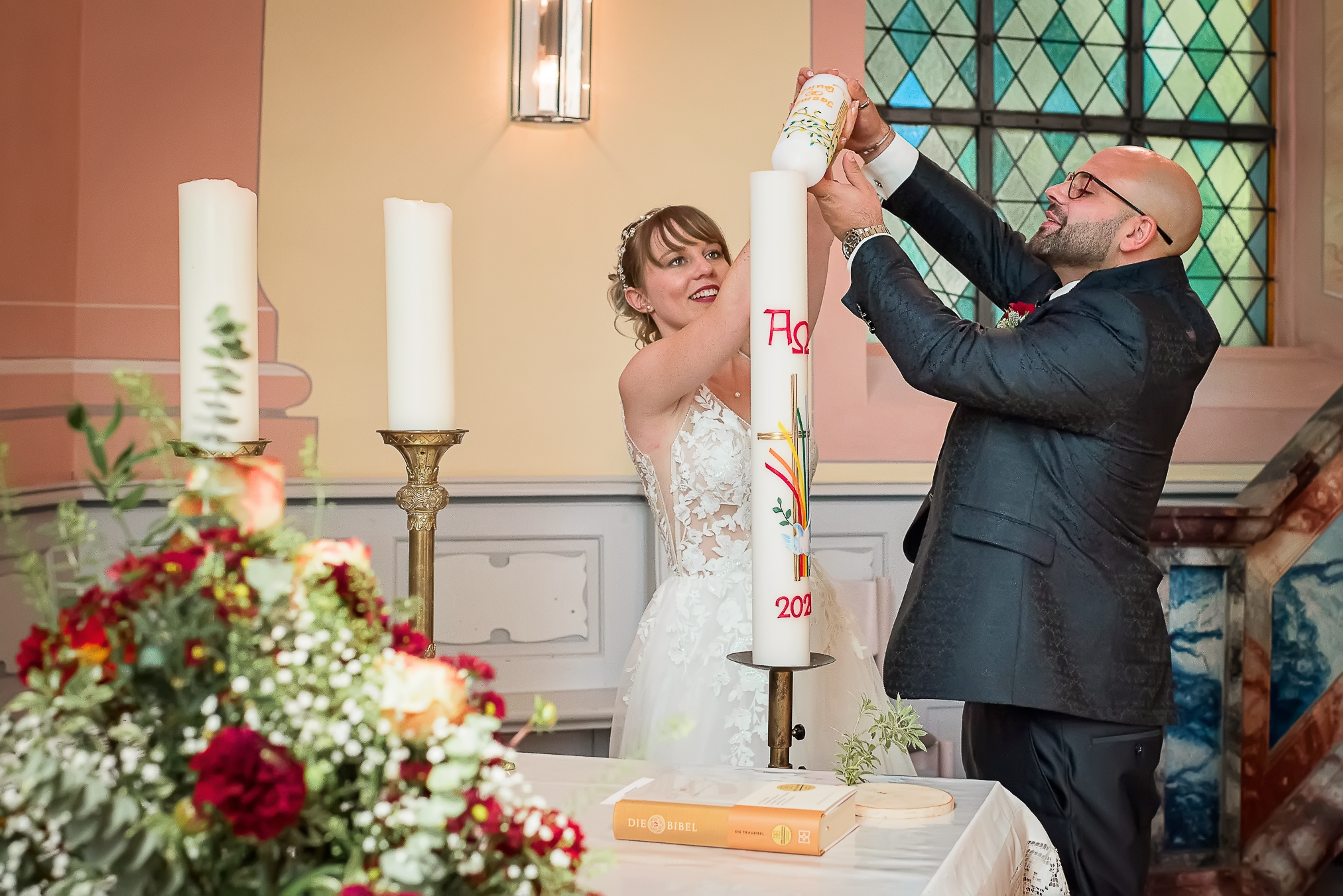 Foto des Moments, in dem das Brautpaar während ihrer kirchlichen Trauung in Lahr die Hochzeitskerze zusammen entzünden.
