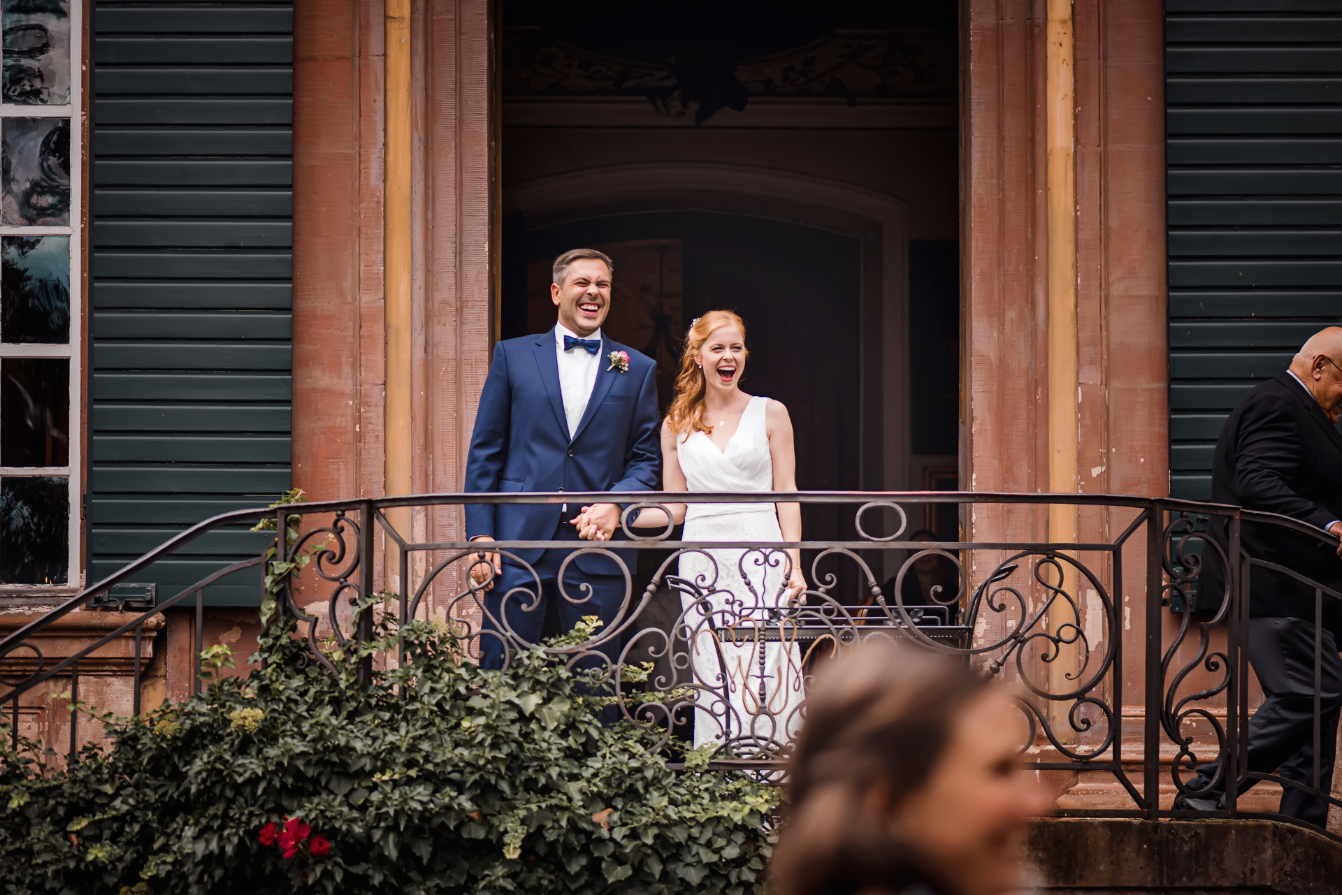 Ein frisch vermähltes Brautpaar schaut auf ihre Gäste und feiert ihre Hochzeit im Schloss Ebnet in Freiburg.