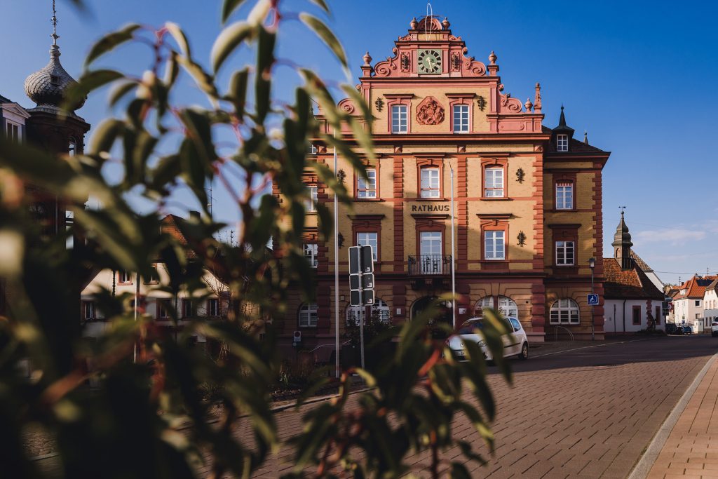 Ein Foto der Fassade des Rathauses in Herbolzheim, aufgenommen an einem wunderschönen Tag mit blauem Himmel von Fotografin Isabela Campos.